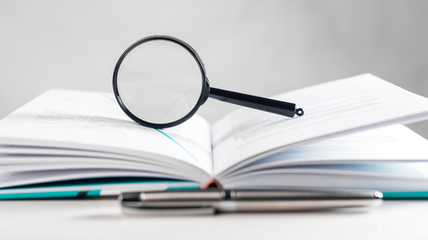 Open book with a magnifying glass