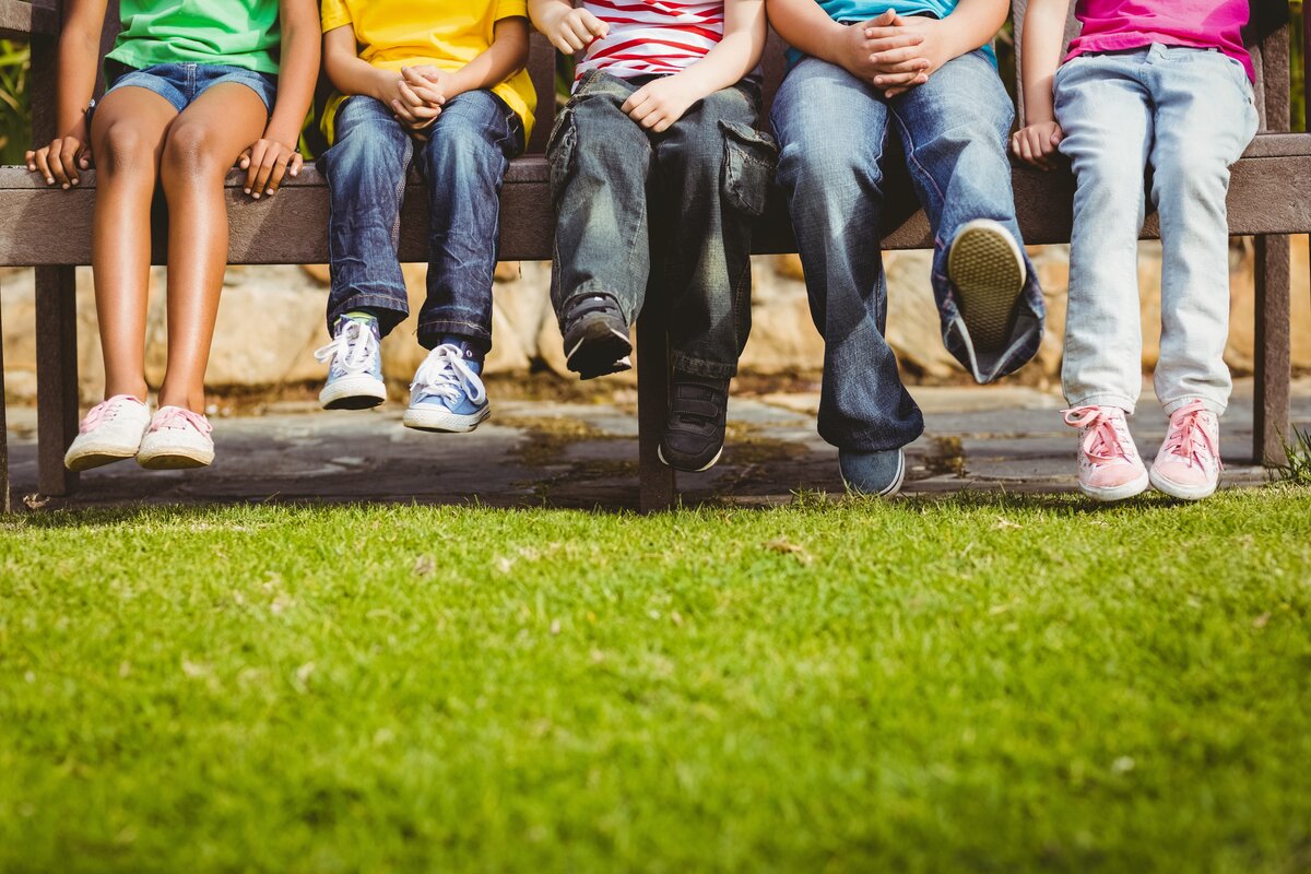 Image shows children sitting on a bench